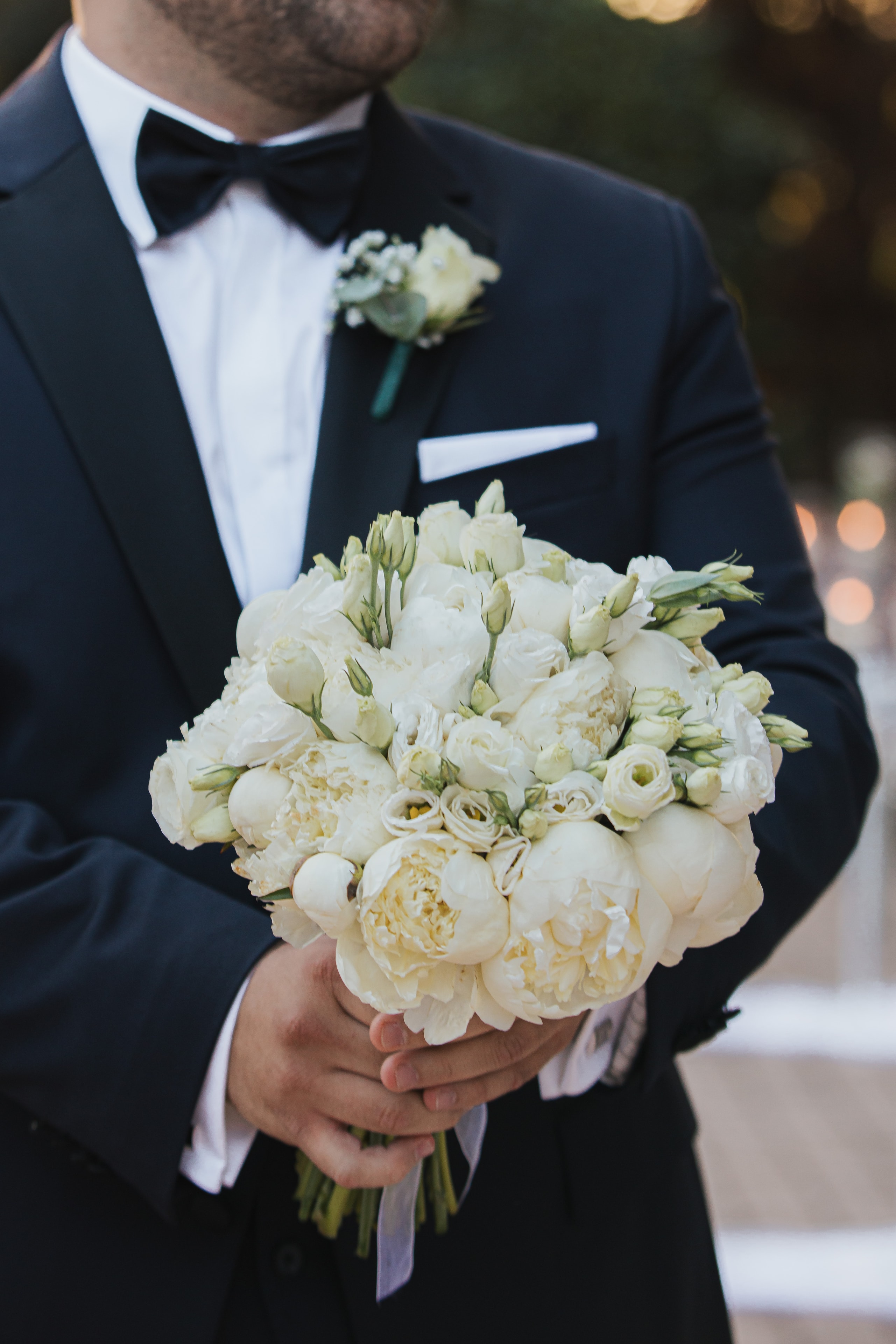Agis holding a white wedding bouquet