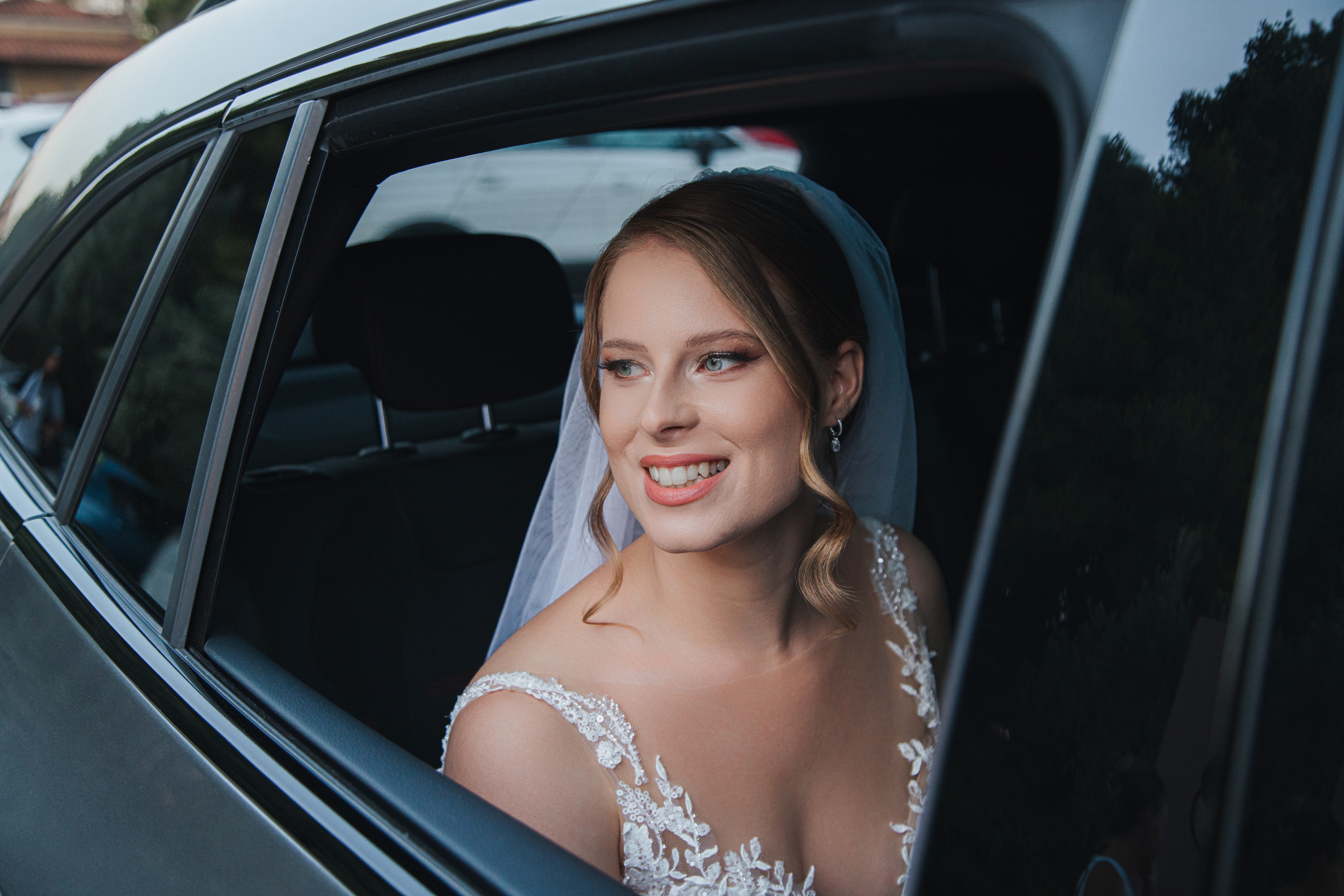 Ioanna smiling from the wedding car