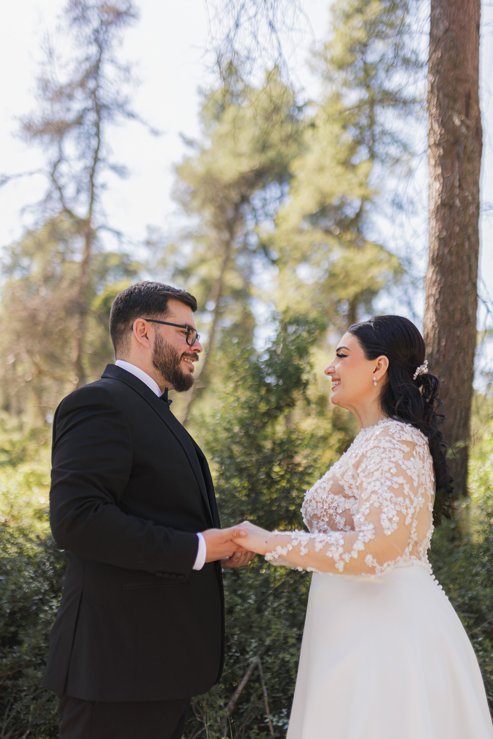 Ioanna and Christos holding hands in a wooded setting