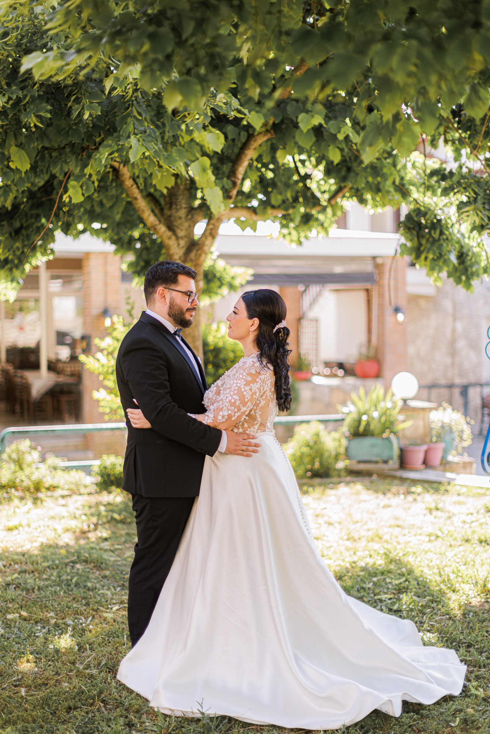 Ioanna and Christos embracing in a leafy garden