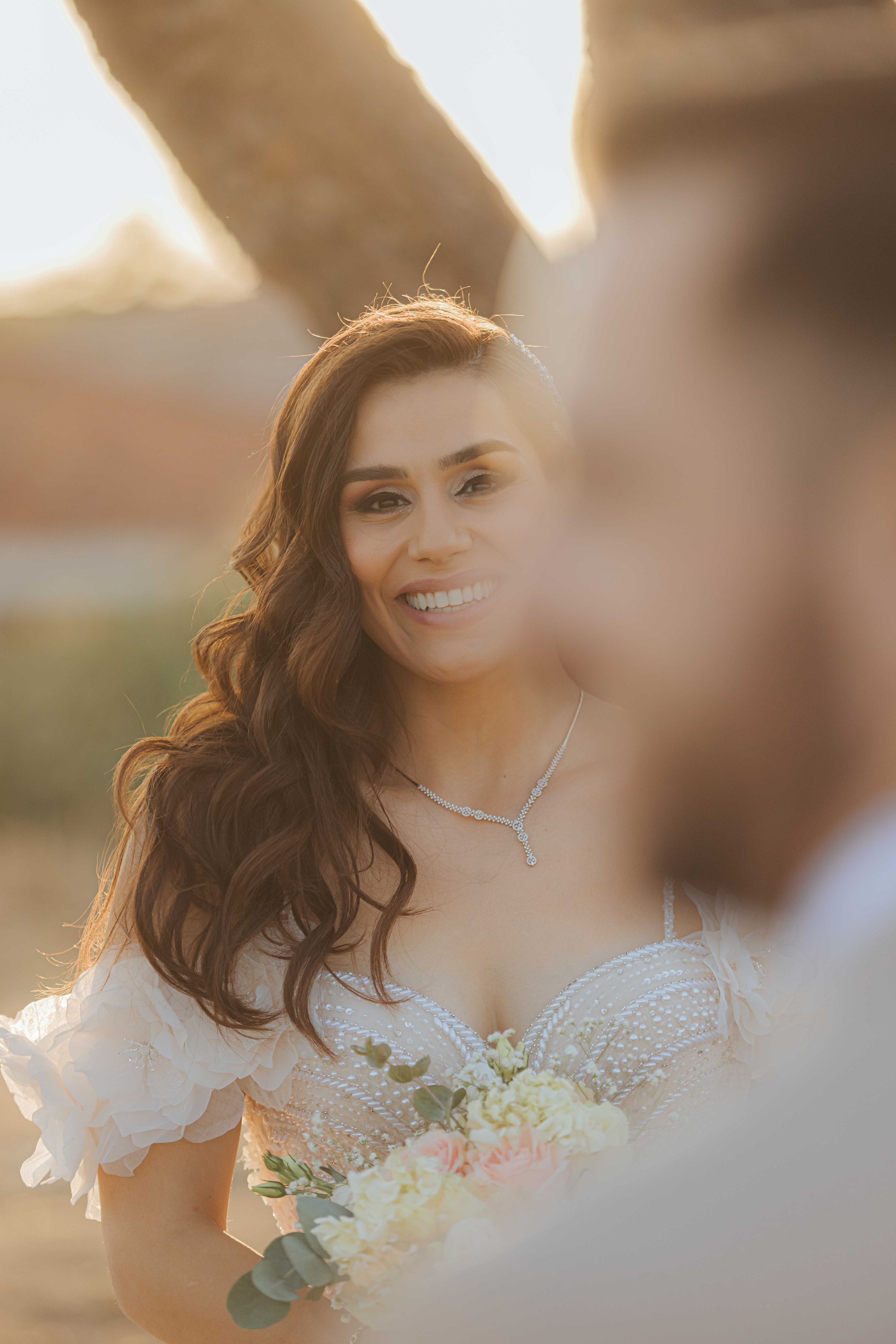 Varvara smiling with her bouquet in warm wedding light